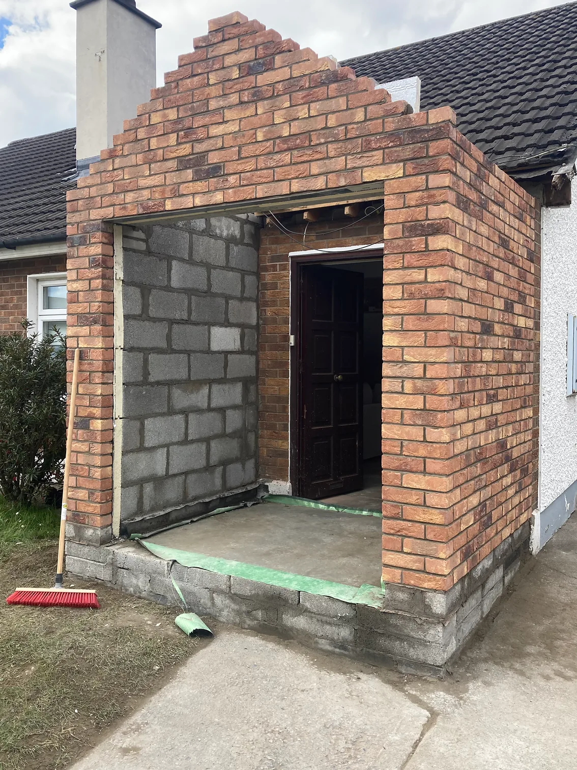 New red brick porch with a stepped gable returning into an existing red brick house